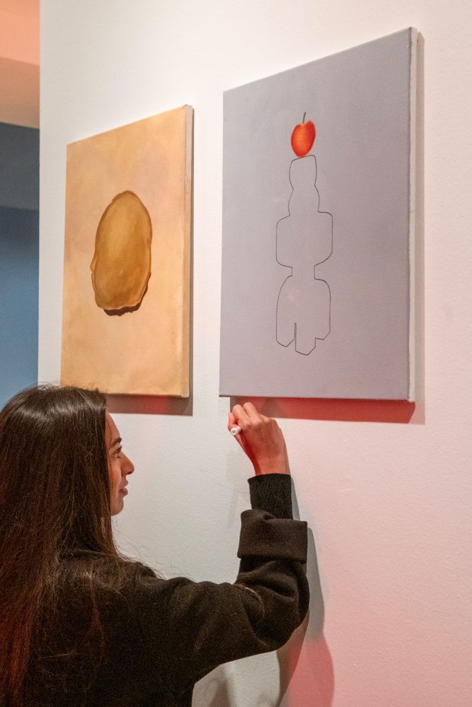 MBO student writes her name under the painting she created for the Brancusi exhibition.