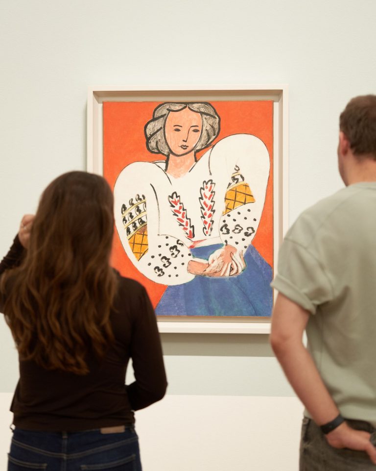 Bezoekers in de tentoonstelling Chez Matisse - Masterpieces from Centre Pompidou kijken naar het werk La Blouse roumaine van Henri Matisse