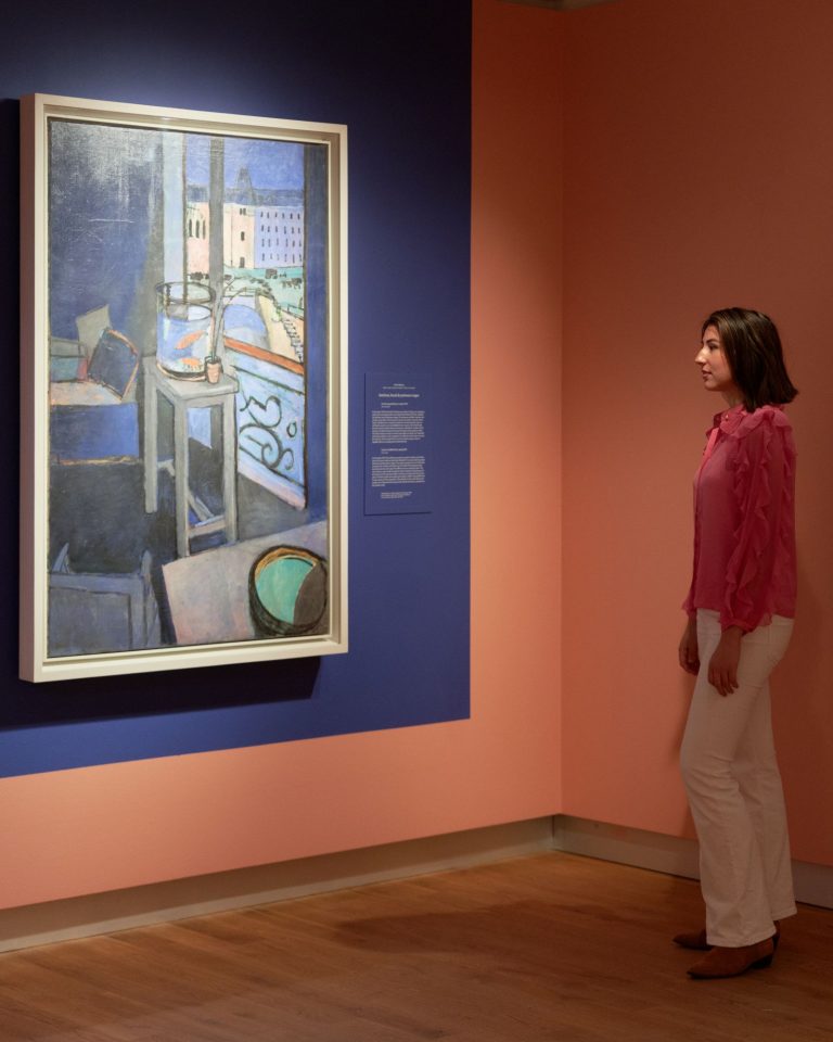 Bezoeker in de tentoonstelling Chez Matisse - Masterpieces from Centre Pompidou kijkt naar het werk 'Interieur, goudviskom' van Henri Matisse